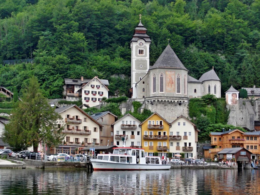 Hallstatt church and lakeside buildings reflected in Lake Hallstatt, Austria