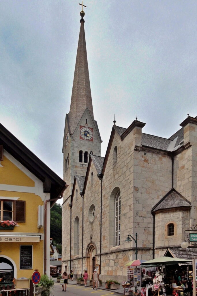 Stone church with tall spire in Hallstatt, Austria