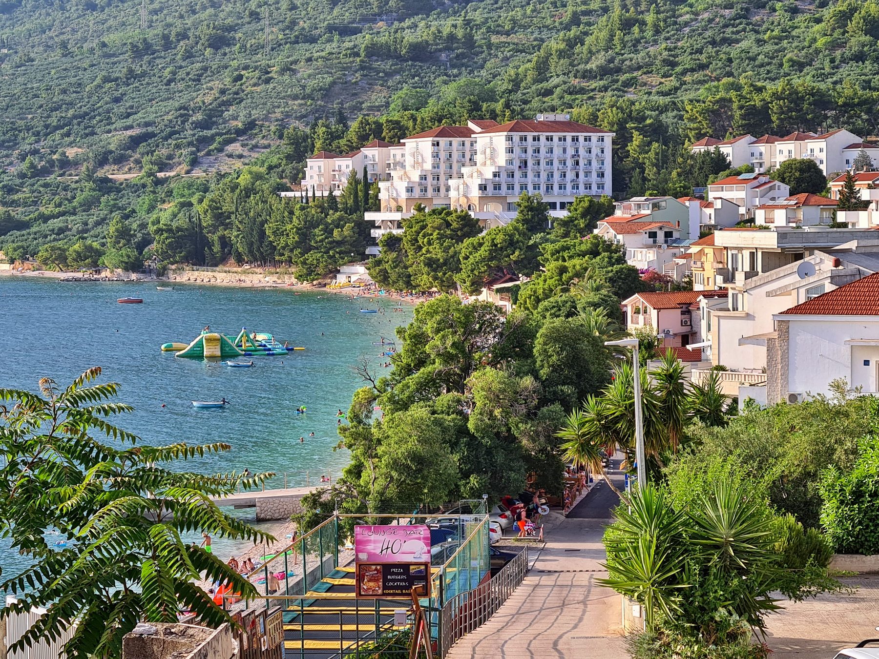 Scenic coastal town of Gradac in Croatia with a beach, clear blue water, and hillside buildings