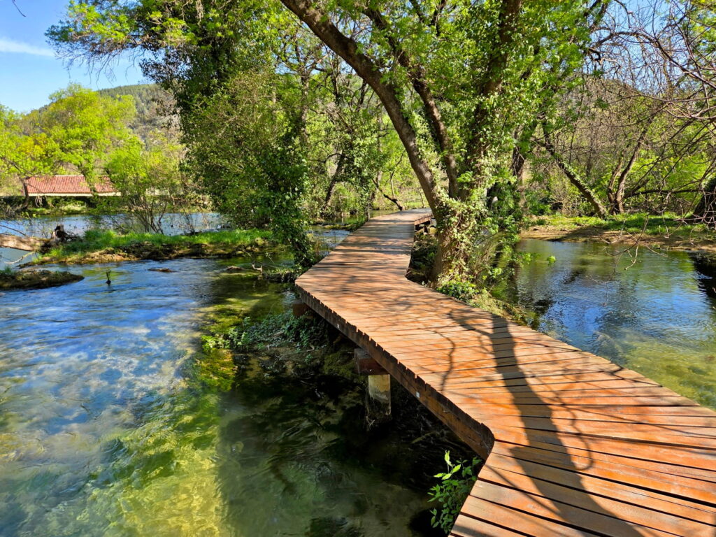 Wooden boardwalk over clear river channels in Krka National Park, Croatia