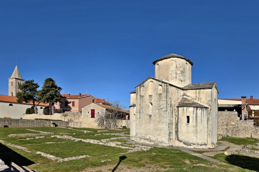 Historic early medieval church with round stone architecture in Nin, Croatia under clear blue sky