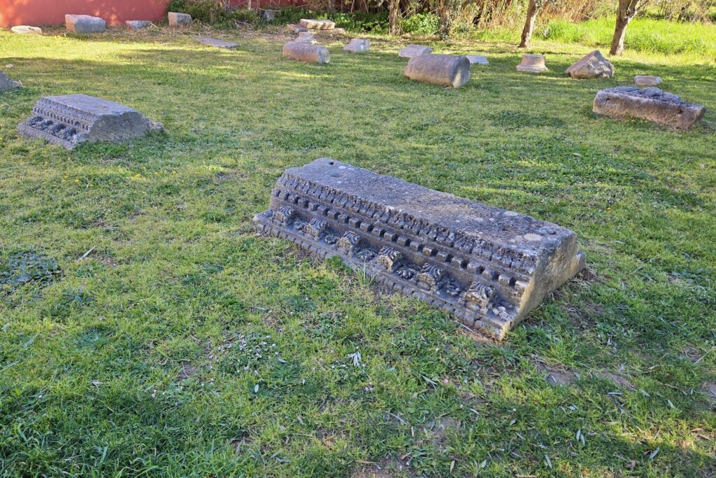 Ancient Roman stone ruins with carved details on grassy ground in Nin, Croatia