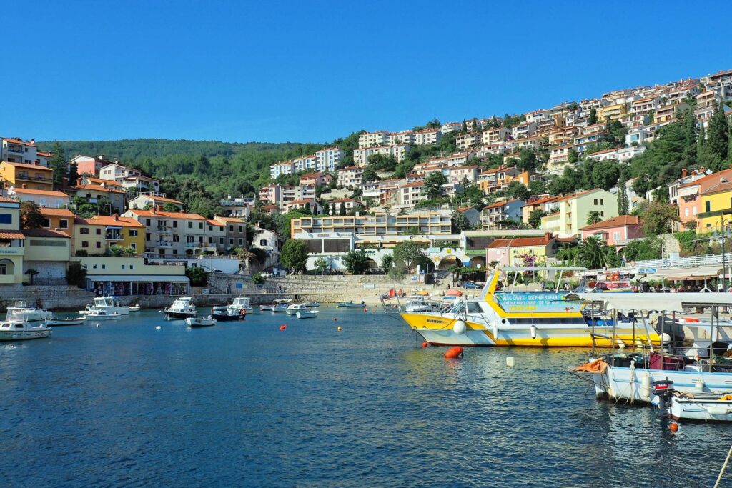 Rabac Bay with boats and hillside homes in Croatia