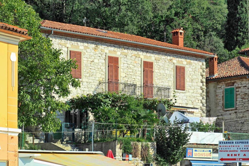 Stone house with shutters above the waterfront in Rabac, Croatia