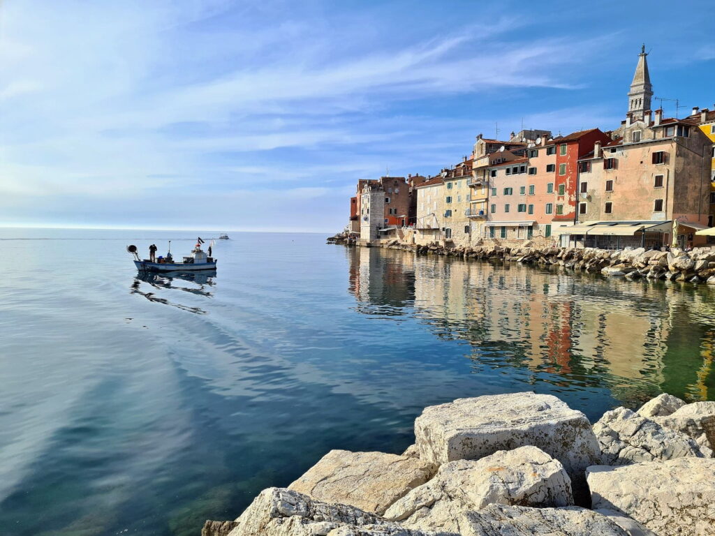 Fishing boat near Rovinj waterfront with reflections on calm Adriatic water