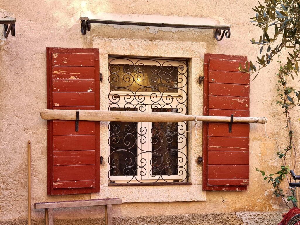 Traditional red shutters and iron window details in Rovinj, Croatia