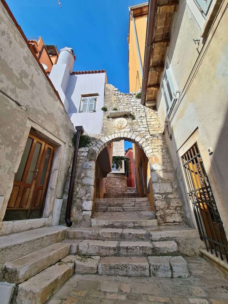 Historic stone archway and narrow street in Rovinj, Croatia