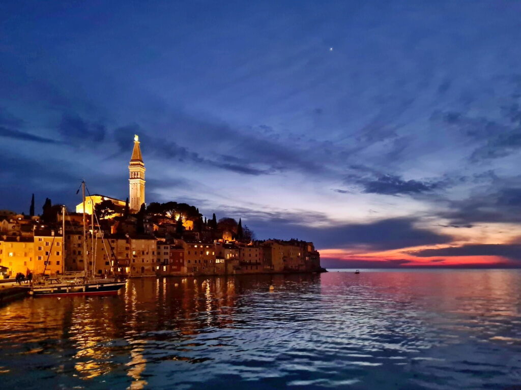 Sunset over Rovinj harbor and illuminated old town in Croatia
