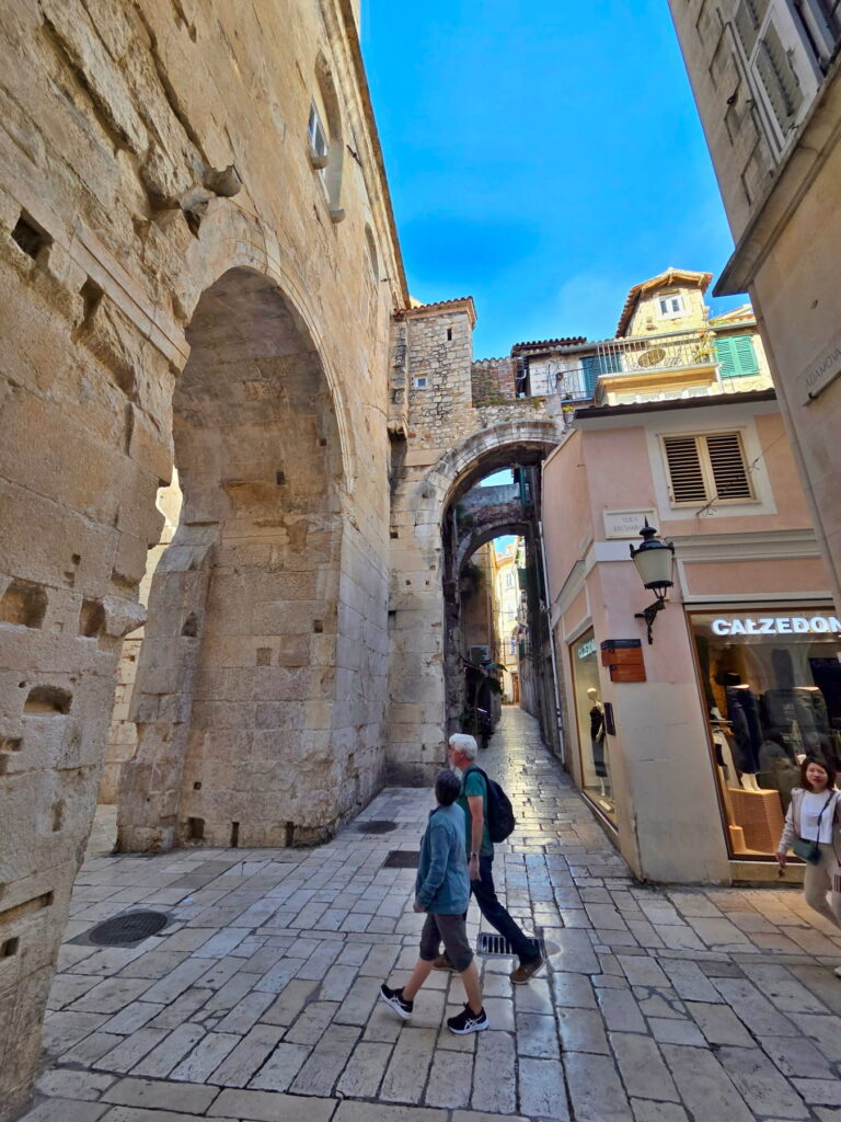 Narrow stone alley and medieval arches in Split Old Town, Croatia.