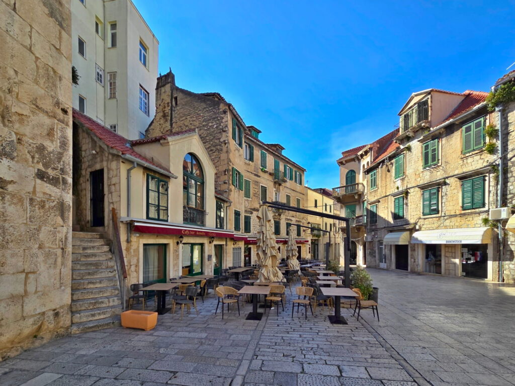 Stone square with cafés and historic houses in Split Old Town, Croatia.