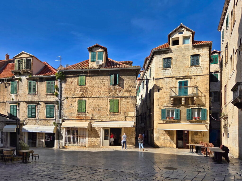 Traditional stone houses with green shutters in Split Old Town, Croatia.