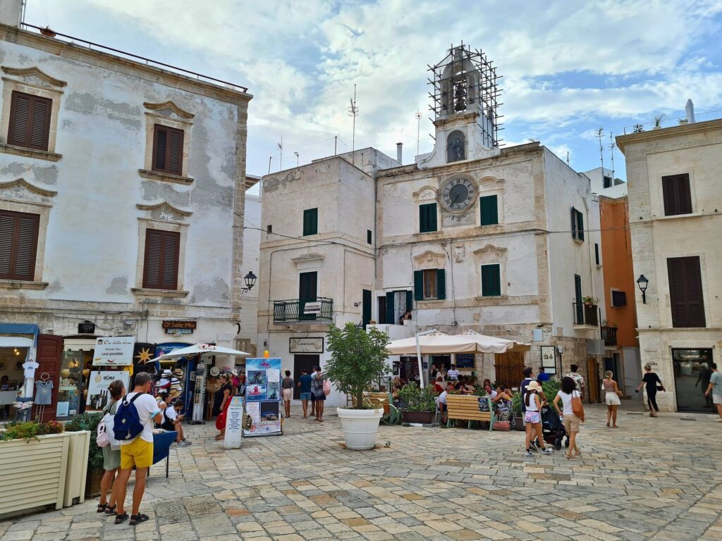 Piazza with church tower in Polignano a Mare, Puglia, Italy