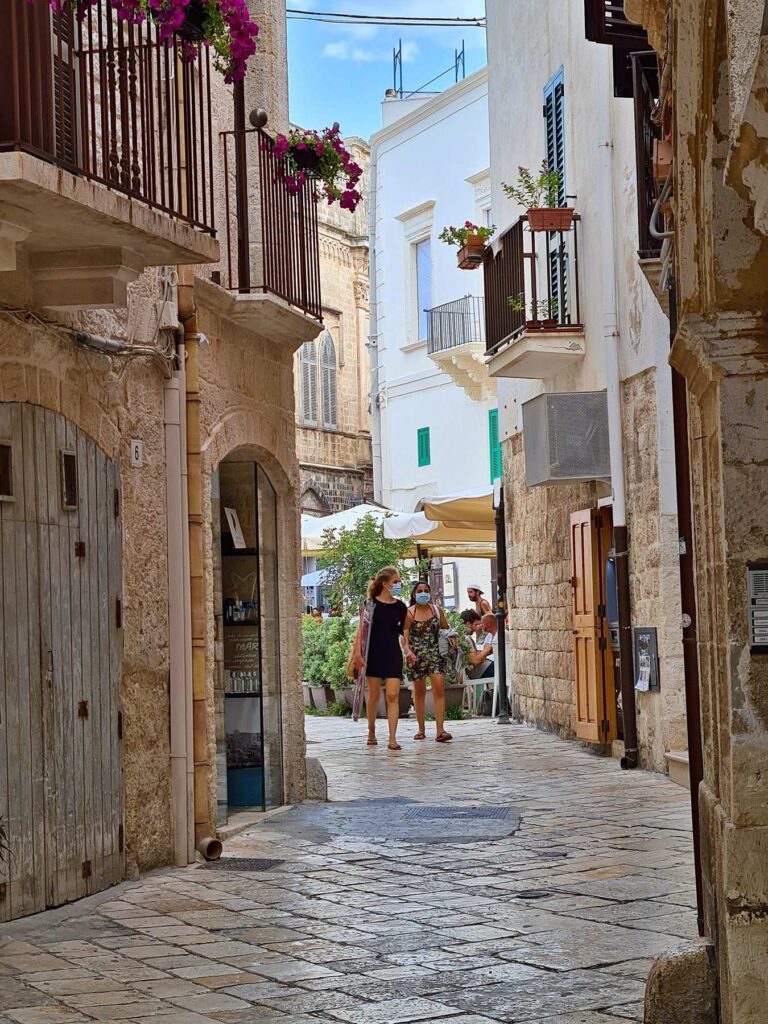 Narrow alley with balconies in Polignano a Mare old town, Italy
