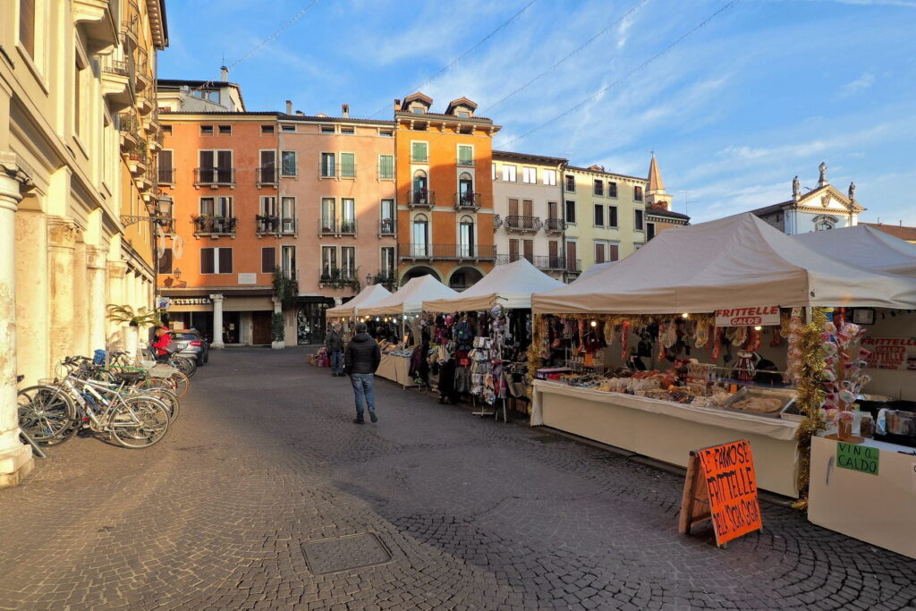 Market stalls and historic buildings in Piazza delle Erbe, Vicenza, Italy