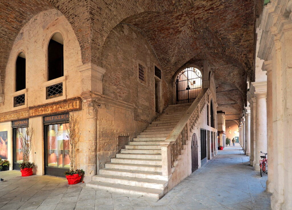 Stone staircase and vaulted arcade inside Basilica Palladiana in Vicenza, Italy