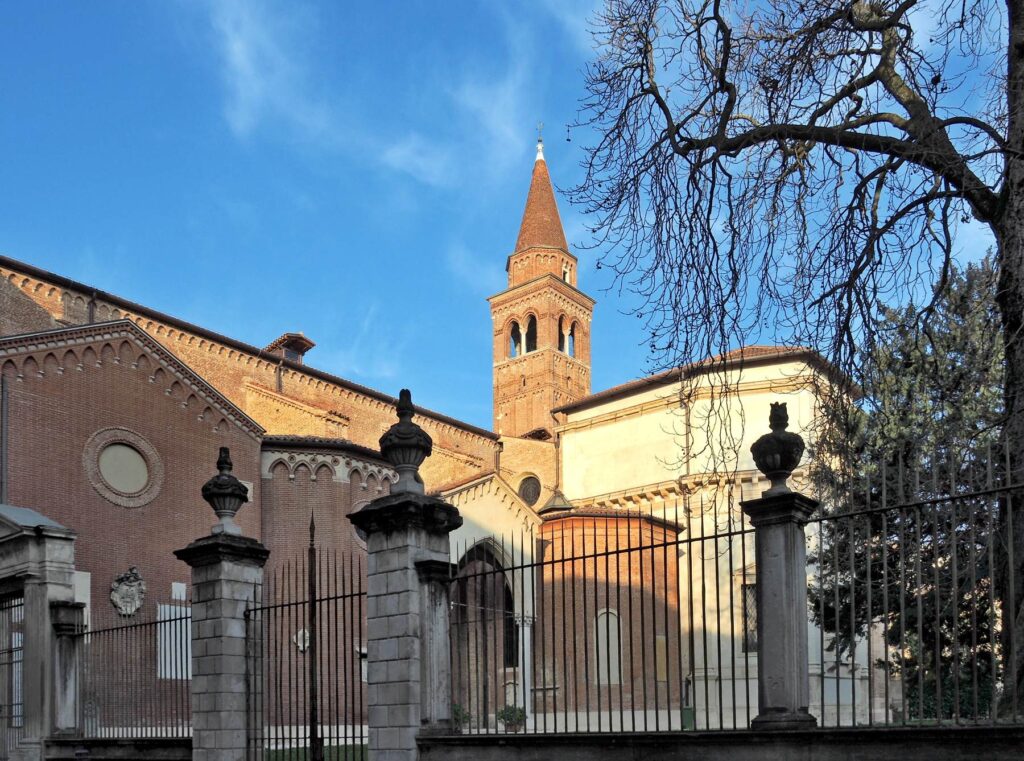 Brick church and bell tower behind iron gates in Vicenza, Italy