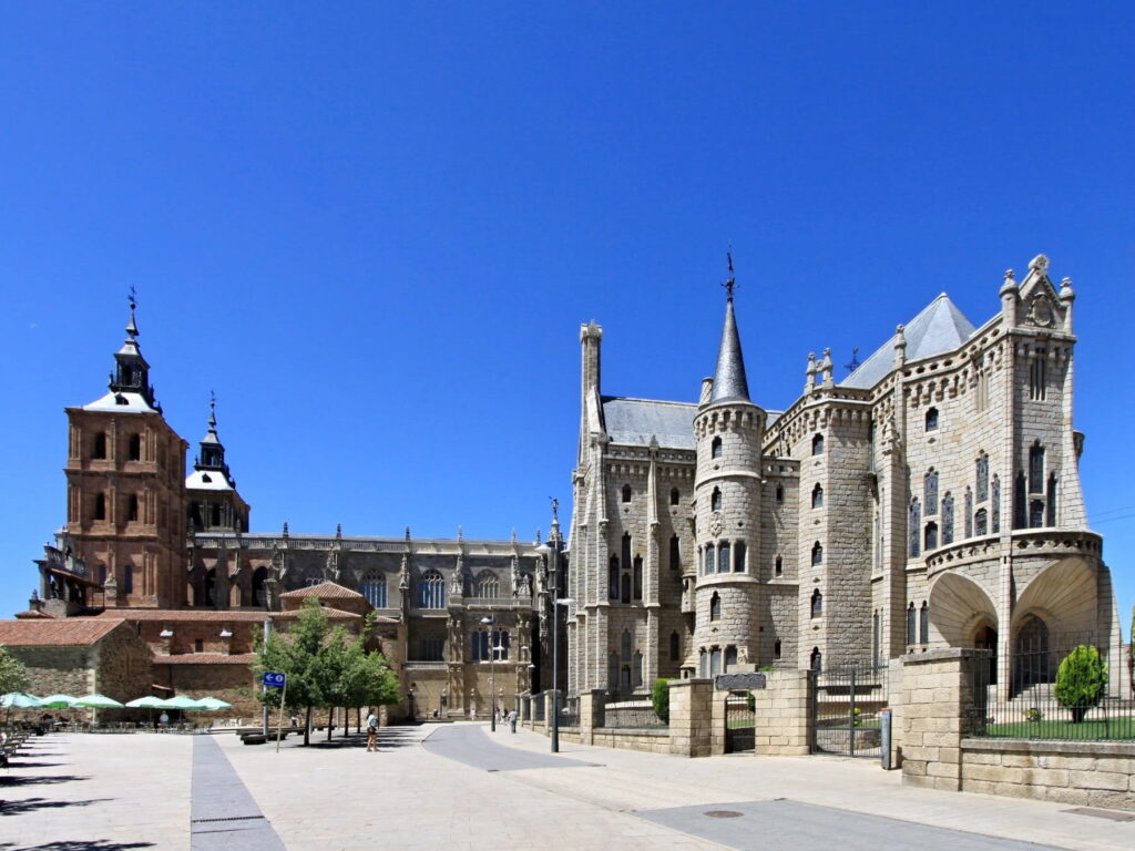 Gaudí Episcopal Palace and Astorga Cathedral in Astorga, Spain under a clear blue sky.