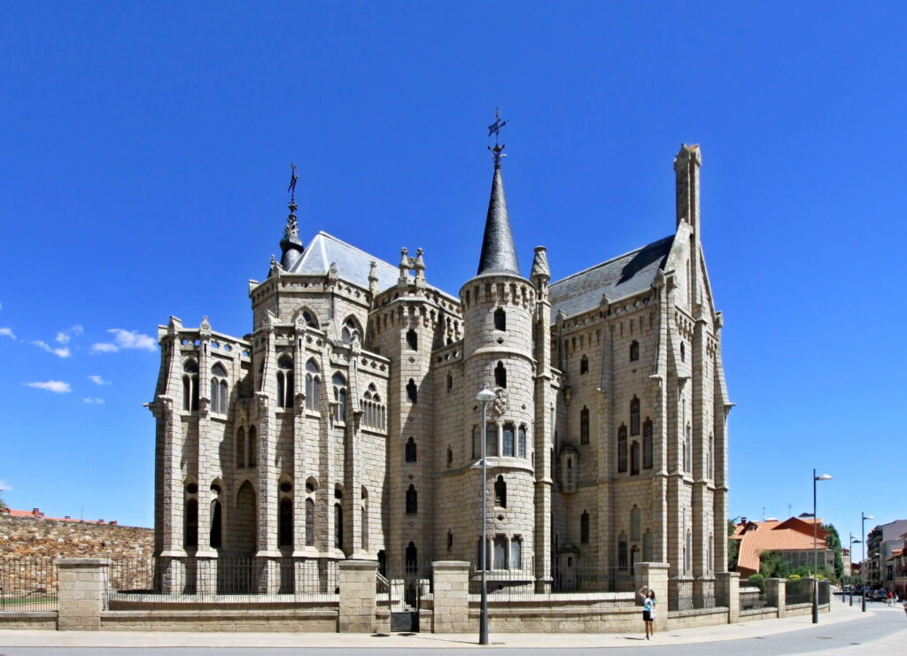 Side view of the Episcopal Palace in Astorga, Spain with stone towers and spires.