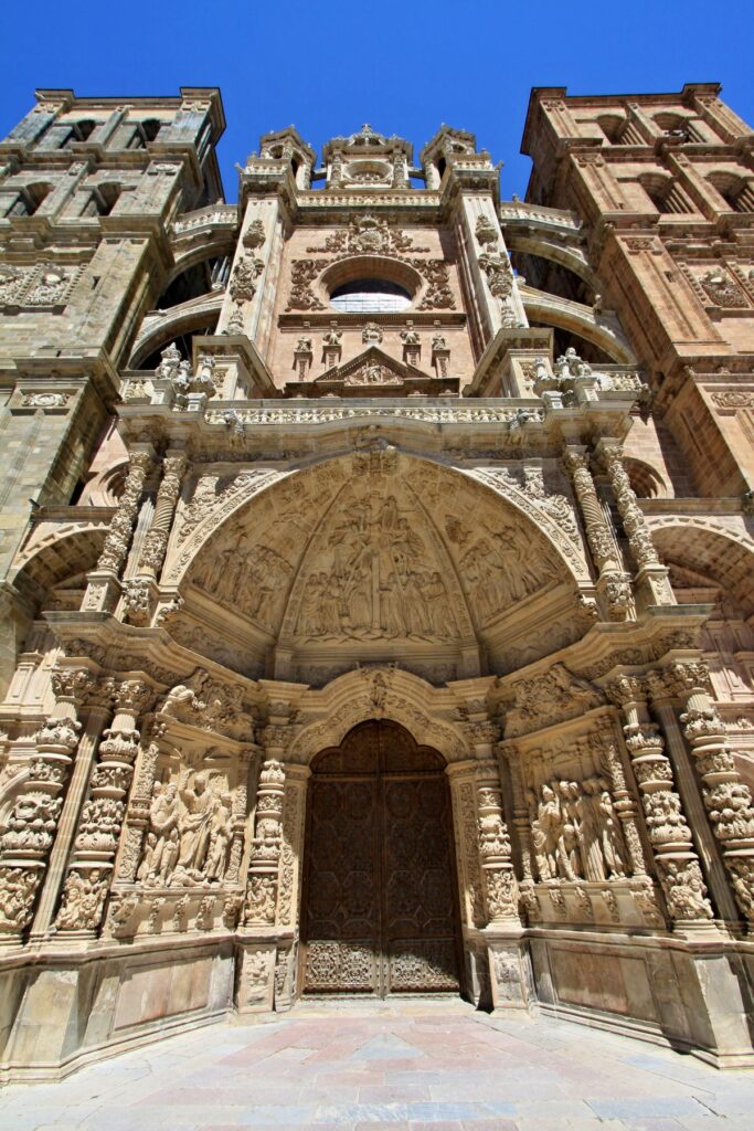 Ornate entrance portal of Astorga Cathedral in Spain with detailed stone carvings.