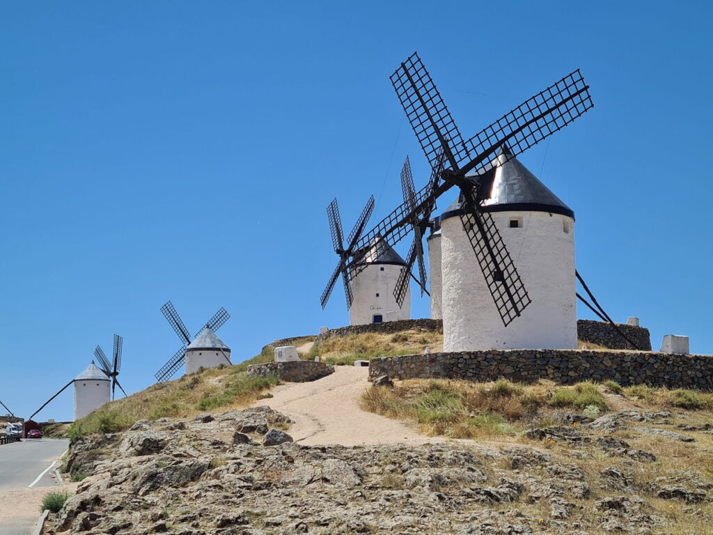Windmills on Cerro Calderico hill in Consuegra, Spain under a clear summer sky.