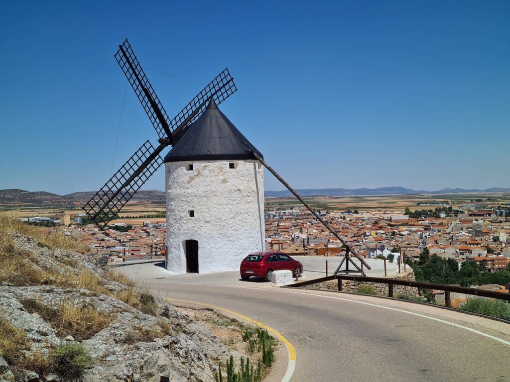 Historic windmill above the town of Consuegra, Spain with valley views behind.