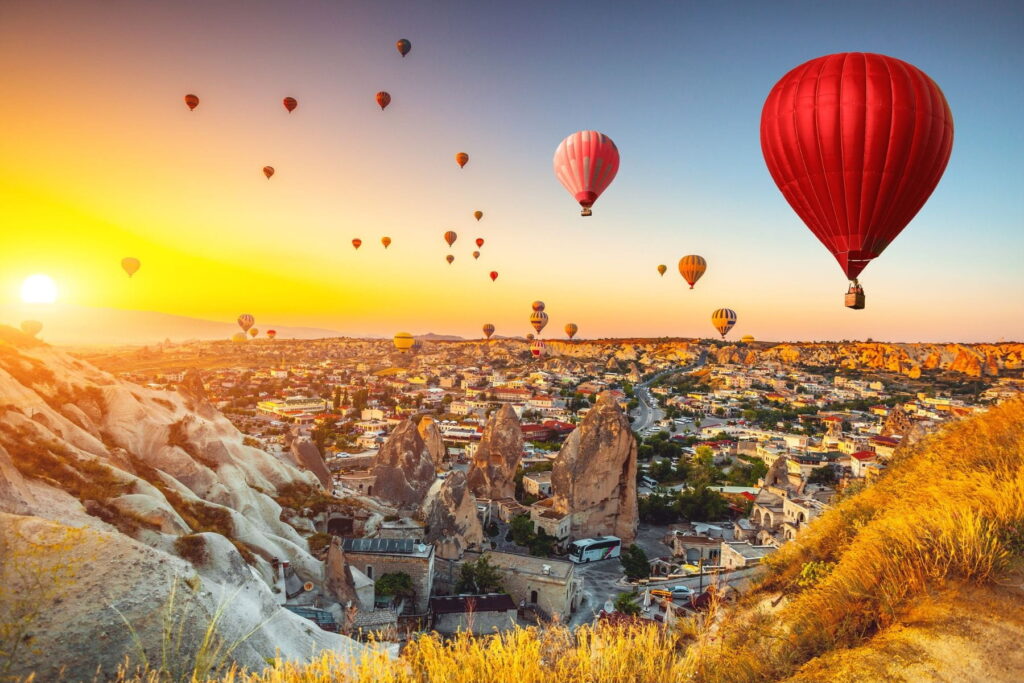 Hot air balloons floating above Cappadocia at sunrise in Turkey