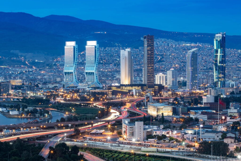 Night skyline of Izmir with modern towers and illuminated roads in Turkey