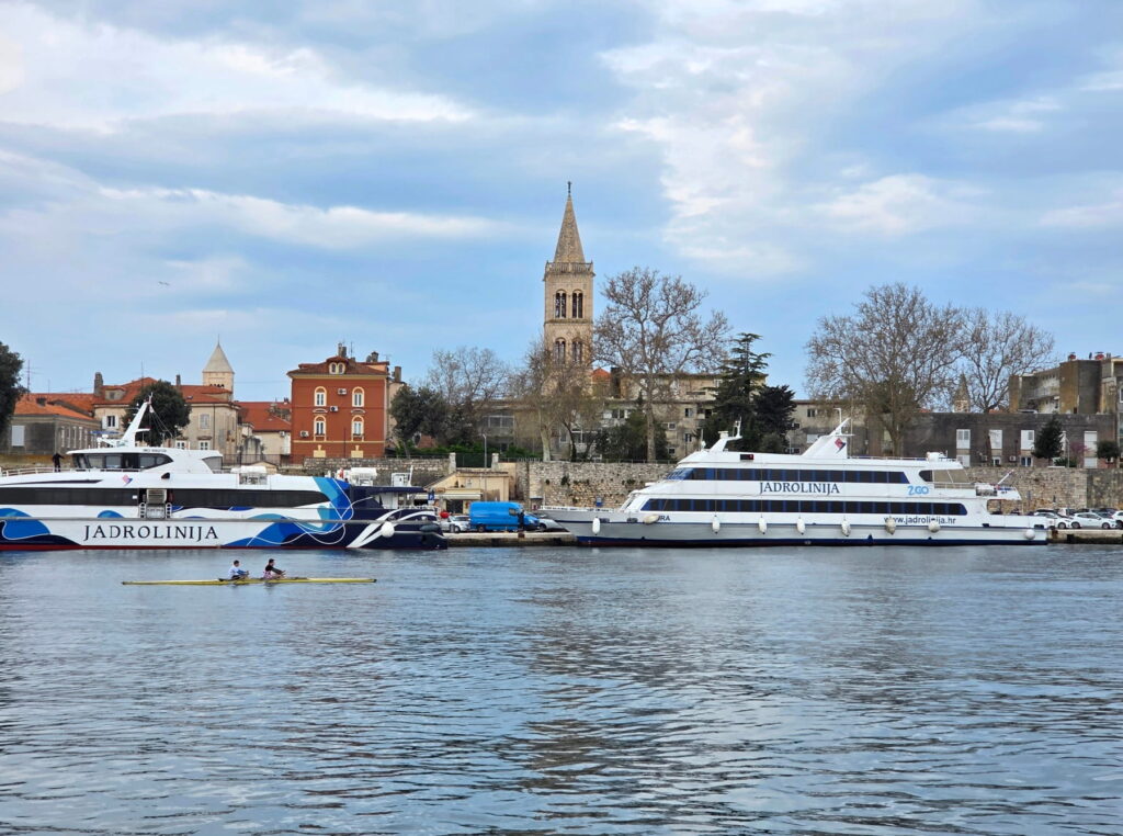 Jadrolinija ferries in Zadar harbor with old town skyline in Croatia
