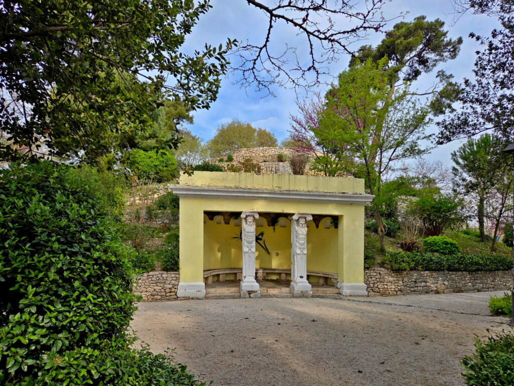Small historic pavilion surrounded by greenery in Zadar park, Croatia